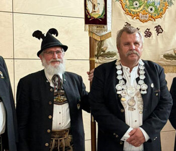 Bezirksschützenkönig Josef Reitner vor der Fahne des Schützenbezirks Oberbayern.